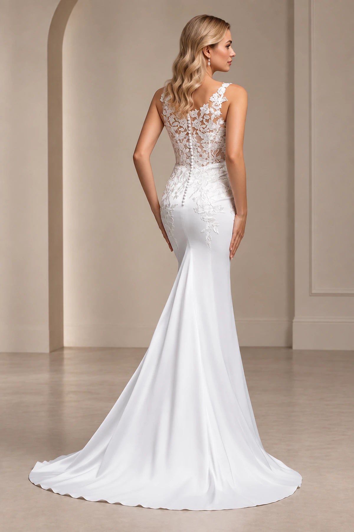 Back view of Vedress mermaid wedding dress with sheer floral lace, covered buttons below the waist and a flowing train.
